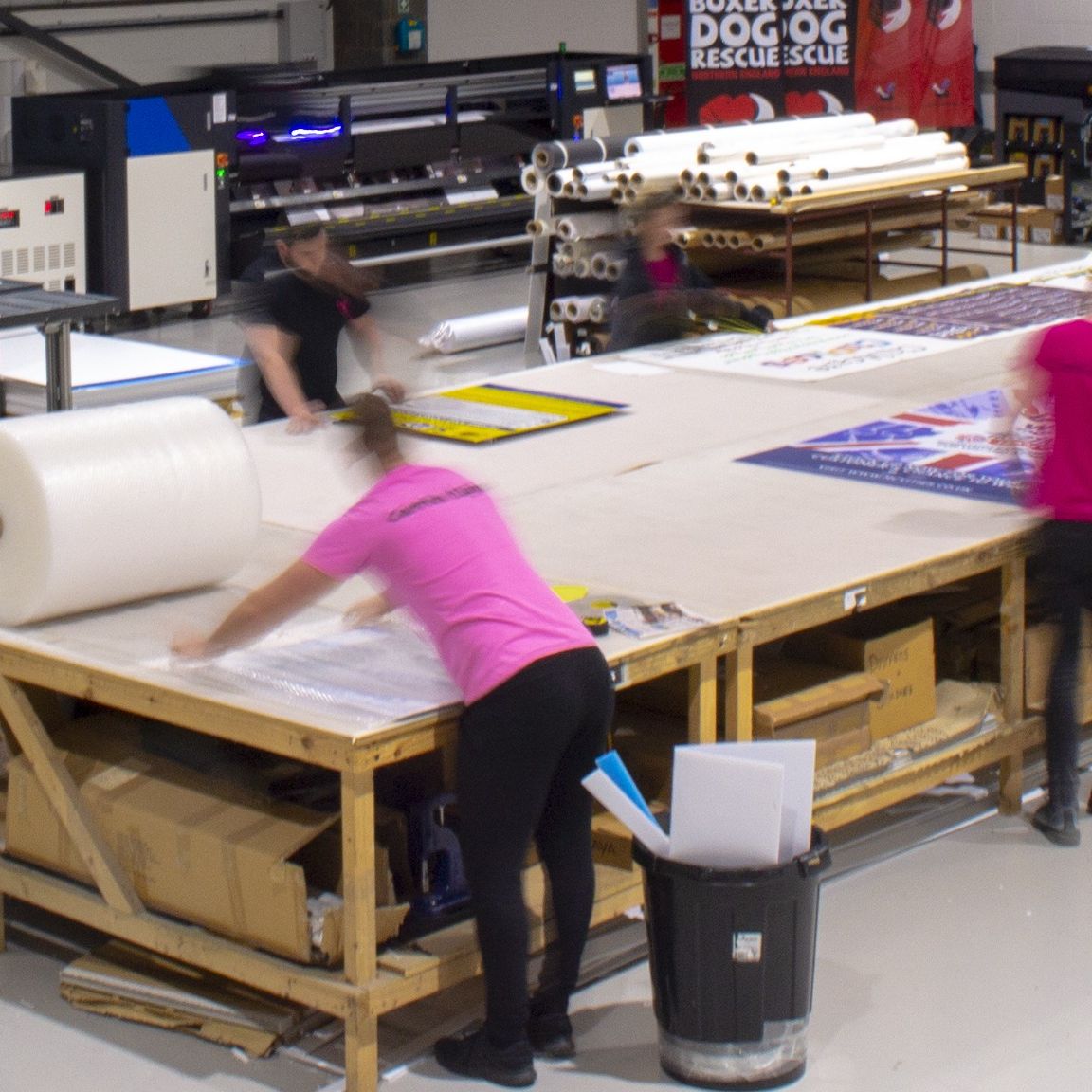 Carrick Signs graphic asking 'Which Material Is The Best for Outdoor Banners?' with examples of pink geometric banner materials and company contact details.